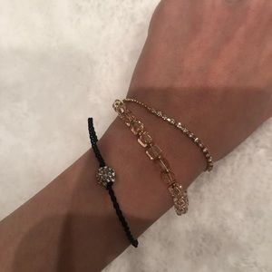 Black bracelet with circular charm.